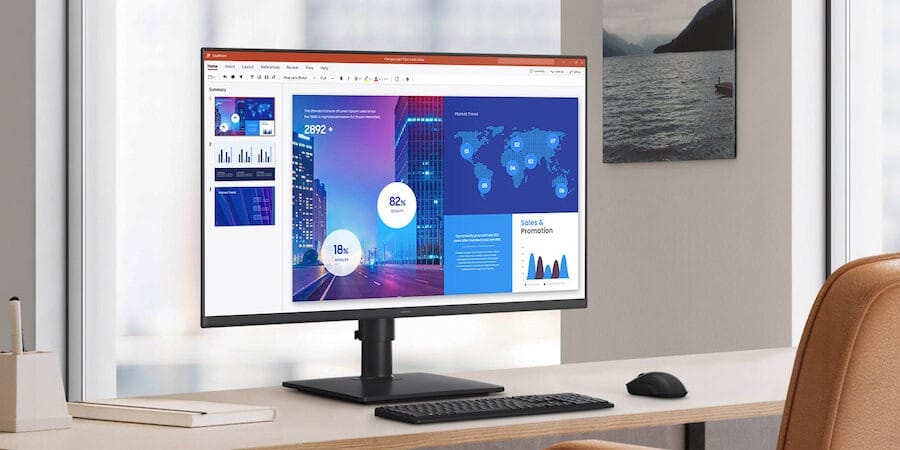 A Samsung desktop monitor displaying a presentation in a bright workspace.