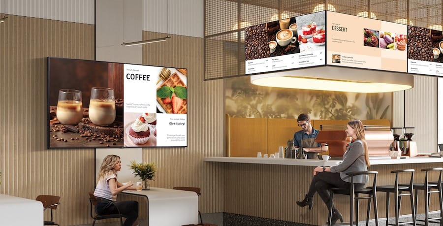 Digital menu boards and a wall display in a café.
