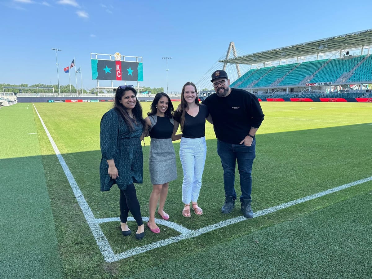 Carolyn and three fellow crew members together on a soccer field during a video shoot.